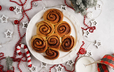 Christmas tree shape cinnamon rolls or cinnabon buns on white plate ready for glazing. Top view.