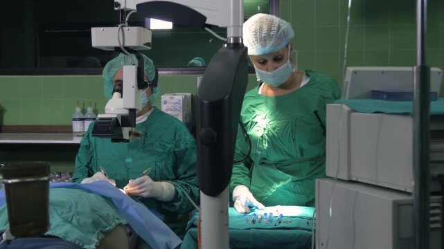 Surgeon using a specialized surgical microscope for precision eye surgery.