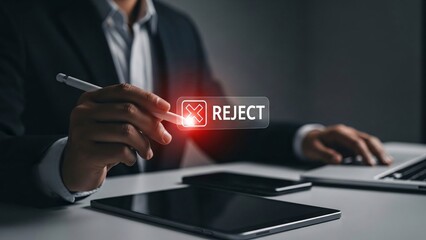 Business professional rejecting a digital application or message with a red reject icon on a modern workspace with electronic devices and a tablet
