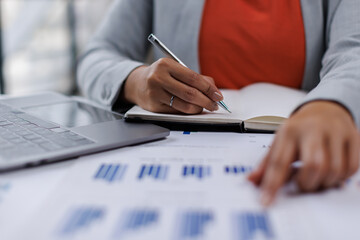 Business woman analysis summary graph reports of business operating expenses and work data about the company's financial statements.
