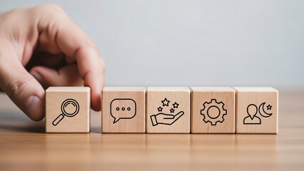 Hand arranging wooden blocks with icons representing search communication support settings and user management for business teamwork collaboration and strategy development