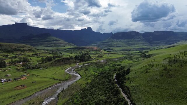 Camera panning left to right over a Small rural community living in a small house in the green foothills of the Drakensberg, South Africa. 4K Aerial Video
