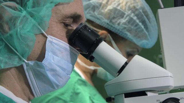 Extremeclose-up of a surgeon using a specialized surgical microscope for precision eye surgery.