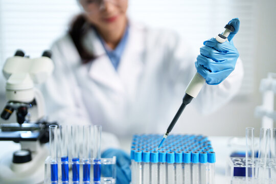 Asian adult scientist researcher experiment liquid pipetting precise accurate work science laboratory medical facility