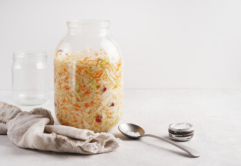 Glass jar with tasty sauerkraut on light background, copy space