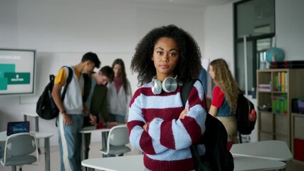 Confident teen student standing in modern classroom. - Powered by Adobe