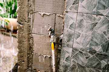 Rainy day on textured outdoor wall with a vintage water tap