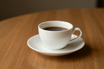 Minimalist white ceramic cup of black coffee on warm wooden table morning