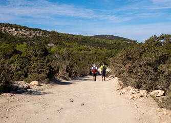 People hiking along a barren, rocky path on a sunny day, exploring the outdoors. Active lifestyle. Akamas Peninsula hiking trail paphos cyprus