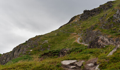People hiking on the slope of a mountain steep cliff. Hikers healthy lifestyle