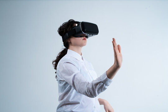 Woman activating futuristic digital technology using virtual reality headset and hand gestures in immersive environment - Powered by Adobe