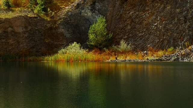 The Emerald Lake, Racos, Romania, with vivid green water, steep rock walls and a serene path along the shore