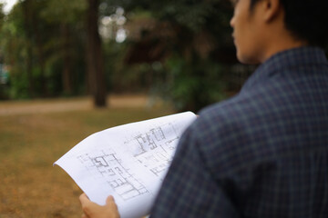 Naklejka premium Construction Professional Holding Blueprints at Building Site