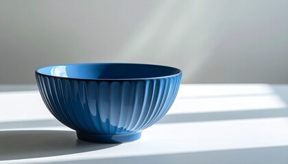 Blue Ceramic Bowl with Vertical Ridges on White Surface in Soft Natural Light Near Window