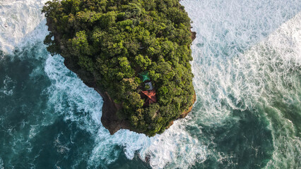 Aerial View Of Dense Island Cliff Surrounded By Turquoise Ocean Waves