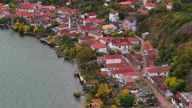 Aerial video of Lin village in Albania, showing hillside homes, dense greenery, and Lake Ohrid in soft autumn light.