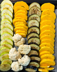 Sliced butternut squash zucchini eggplant cauliflower baking sheet