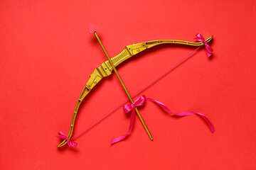 Golden cupid's bow on red background. Valentine's Day celebration