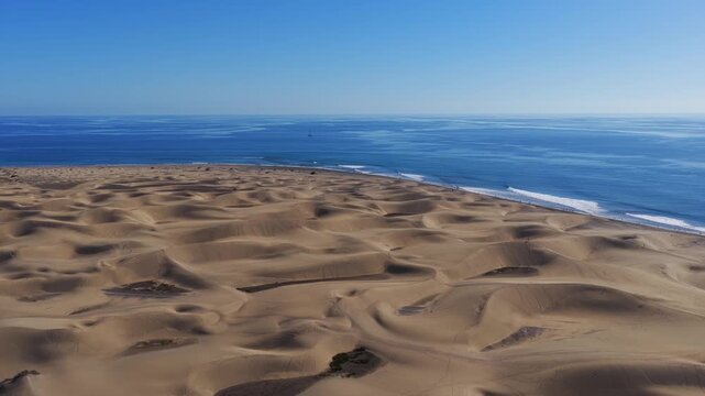 Cinematic 4K Aerial of the Maspalomas Special Natural Reserve Dunes at Sunrise, showcasing the World Biosphere Reserve and Volcanic Coastline, Gran Canaria, Spain