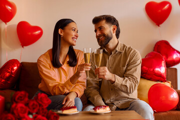 Valentine's Day celebration. Spouses clinking glasses drinking wine celebrating holiday, having...