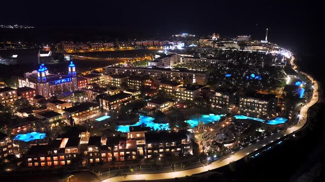 Nighttime Aerial of the Faro de Maspalomas Lighthouse, El Oasis Palm Grove, and the Elite 5-Star Resort Strip of Meloneras, Gran Canaria, Spain