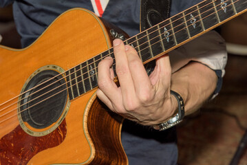 Fototapeta premium guitarist playing a barre chord on a semi-acoustic guitar