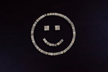 Smiley Face Made of Wooden Blocks on a Dark Background