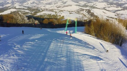 Old ski station on a snowy mountain slope with a lot of people on skis and snowboards