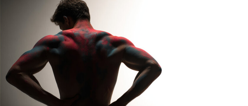 Muscular man with painted back standing confidently.