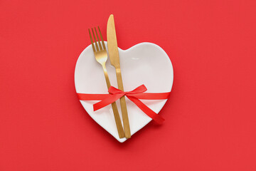 Table setting for Valentine's Day with ribbon on red background