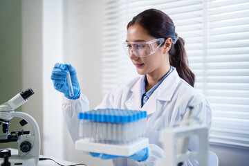 Asian adult woman scientist performs laboratory research experiments examining samples scientific discovery healthcare innovation modern science lab setting
