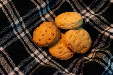 Warm Homemade Cookies Resting On Black And White Plaid Fabric For A Cozy Snack Scene.