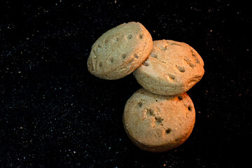 Stacked Round Shortbread Cookies on a Dark Surface with Warm Lighting
