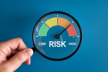 Hand holding risk gauge with low to high indicator