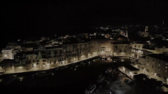 Notte di Natale al Porto Vecchio di Monopoli con le proiezioni e le barche illuminate, visto dal drone - Bari, Puglia, Italia