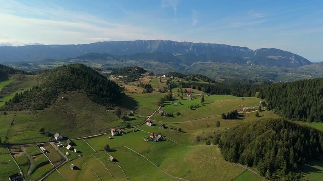 Scenic Aerial Drone Shot of Fundata Village and Rucar-Bran Pass with Piatra Craiului Mountains Ridge in Transylvania Romania