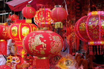 Fototapeta premium Vibrant red Chinese lanterns illuminate a festive market stall with traditional decorations
