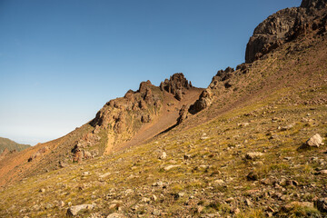 Winding gravel road in the high mountains of Tien Shan with a view of the massive Tuyuksu glacier. Remote alpine landscape in Central Asia