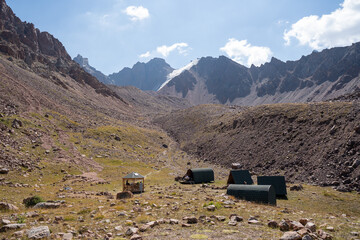 Winding gravel road in the high mountains of Tien Shan with a view of the massive Tuyuksu glacier. Remote alpine landscape in Central Asia