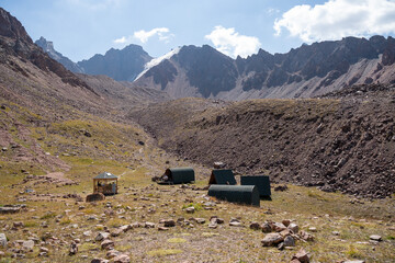 Winding gravel road in the high mountains of Tien Shan with a view of the massive Tuyuksu glacier. Remote alpine landscape in Central Asia