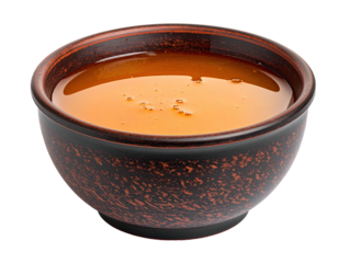 A close-up shot of a small bowl filled with liquid, isolated against a black background