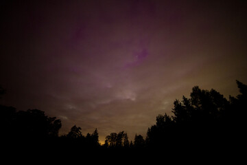 Strong northern lights over forest. Geomagnetic storm and night landscape.