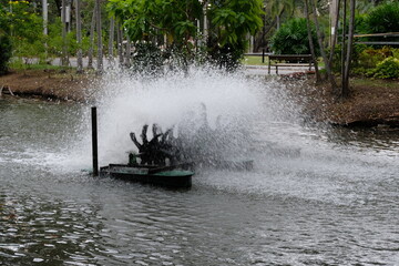 Water aeration turbine spinning vigorously in a pond, creating a large spray