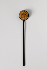 Homemade walnut and chili pepper sauce in black teaspoon