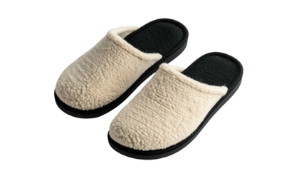 A pair of beige, fluffy house slippers with black soles and inner lining against black background