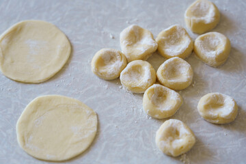 Preparing dough circles and filled pasta in a home kitchen during the afternoon
