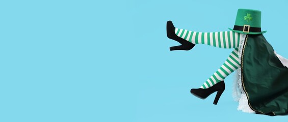 Female legs in striped stockings and leprechaun's hat on blue background with space for text. St....
