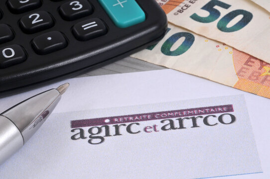 Vannes, France, 2 janvier 2026 : Formulaire de demande de retraite compl&eacute;mentaire de l'Agirc-Arrco avec un stylo, une calculatrice et des billets de banque en euros en gros plan