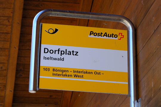 Iseltwald, Switzerland-Oct.1st 2025: PostAuto bus stop sign at Dorfplatz in Iseltwald, Switzerland