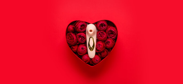 Gift box with beautiful rose flowers and vibrator on red background